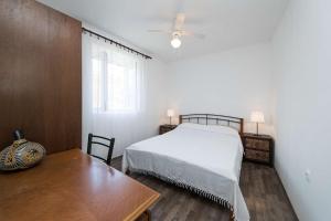 a bedroom with a bed and a table and a window at Holiday house with WiFi Novi Vinodolski - 15397 in Novi Vinodolski