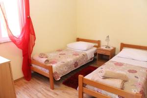 a small bedroom with two beds and a window at Apartments with WiFi Zlarin - 15409 in Zlarin