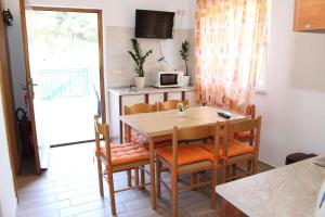 a kitchen and dining room with a table and chairs at Apartments with WiFi Zlarin - 15409 in Zlarin