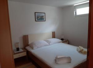 a bedroom with a bed with white sheets and a window at Apartments with parking space Cizici, Krk - 15415 in Malinska