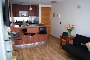 a kitchen with a table and chairs in a room at Lobato Apartments in Santiago