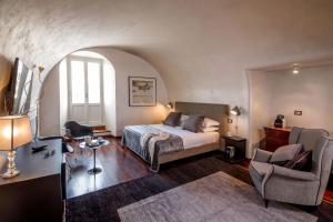 a bedroom with a bed and a chair at Palazzo De Cupis - Suites and View in Rome