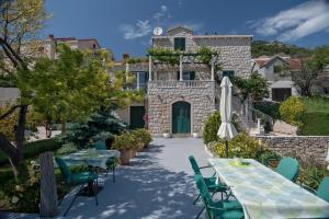 a patio with tables and chairs and a building at Apartments and rooms with parking space Bol, Brac - 15418 in Bol