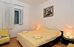 a bedroom with a bed with yellow towels on it at Apartments and rooms with parking space Bol, Brac - 15418 in Bol