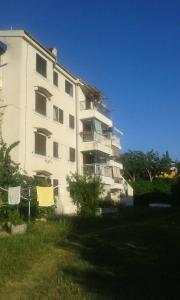 a tall white building with chairs in front of it at Apartments by the sea Cres - 15426 in Cres