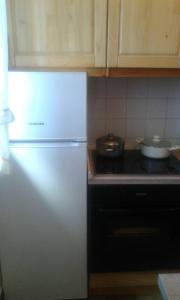 a white refrigerator in a kitchen next to a stove at Apartments by the sea Cres - 15426 in Cres