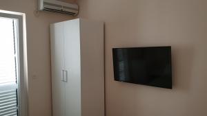 a white cabinet with a flat screen tv on a wall at Double Room Hvar 15378a in Hvar