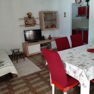 ein Esszimmer mit einem Tisch und roten Stühlen in der Unterkunft Apartments by the sea Brist, Makarska - 15443 in Podaca