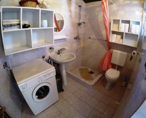 ein Badezimmer mit einer Waschmaschine und einem Waschbecken in der Unterkunft Holiday house with a parking space Lozisca, Brac - 15444 in Ložišće