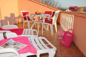 a patio with a table and chairs on a balcony at Apartments with a parking space Barbat, Rab - 15459 in Rab