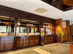bar w restauracji z drewnianymi panelami w obiekcie River Grand Hotel w mieście Hat Yai