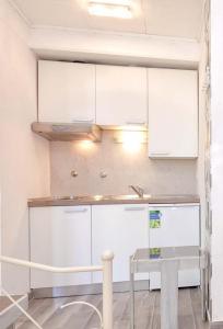 a kitchen with white cabinets and a table at Apartments with WiFi Stari Grad, Hvar - 15464 in Stari Grad