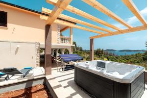 a hot tub on the patio of a house at Family friendly house with a parking space Prizba, Korcula - 15468 in Prizba
