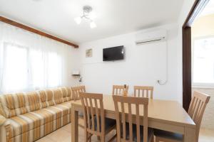 a living room with a table and a couch at Family friendly house with a parking space Prizba, Korcula - 15468 in Prizba