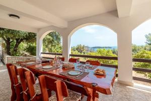 a dining room with a table and chairs and windows at Family friendly house with a parking space Prizba, Korcula - 15468 in Prizba