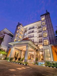 a large white building with a gazebo in front of it at Grand Serela Yogyakarta in Yogyakarta