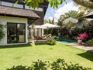 a garden with a swimming pool and a house at Villa Shamballa - Bingin - 2 Bedrooms in Uluwatu