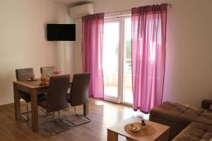 a living room with a table and pink curtains at Apartments with parking space Podaca, Makarska - 15475 in Podaca