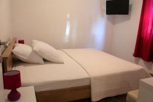 a bed with white sheets and pillows in a room at Apartments with parking space Podaca, Makarska - 15475 in Podaca
