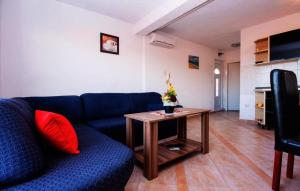 ein Wohnzimmer mit einem blauen Sofa und einem Tisch in der Unterkunft Apartments with a parking space Rogoznica - 15497 in Rogoznica