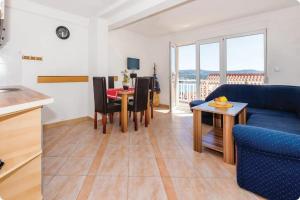 ein Wohnzimmer mit einem blauen Sofa und einem Tisch in der Unterkunft Apartments with a parking space Rogoznica - 15497 in Rogoznica