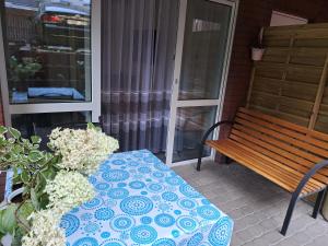 een tafel en een bank op een veranda bij Viktoria in Ełk