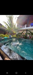a swimming pool in front of a building at Swara Homestay 2 in Nusa Lembongan