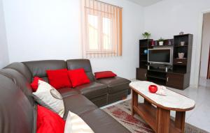 sala de estar con sofá marrón y almohadas rojas en Apartments by the sea Drvenik Mali (Drvenik) - 15535 en Mali Drvenik