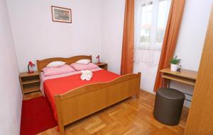 1 dormitorio pequeño con 1 cama con manta roja en Apartments by the sea Drvenik Mali (Drvenik) - 15535 en Mali Drvenik