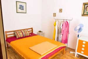 a bedroom with a bed with a orange blanket and a fan at Holiday house with a parking space Pirovac, Sibenik - 15538 in Pirovac