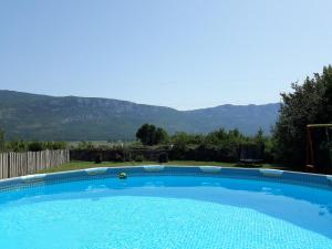 a large blue swimming pool with mountains in the background at Apartments with a swimming pool Cepic, Central Istria - Sredisnja Istra - 15542 in Kostrčani