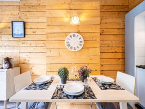 jadalnia ze stołem i zegarem na ścianie w obiekcie Charmant appart rénové 4 pers, sauna, piscine, proche thermes et télécabine - Saint-Lary Village - FR-1-296-435 w mieście Saint-Lary-Soulan