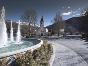 fontanna przed budynkiem z kościołem w obiekcie Charmant appart rénové 4 pers, sauna, piscine, proche thermes et télécabine - Saint-Lary Village - FR-1-296-435 w mieście Saint-Lary-Soulan