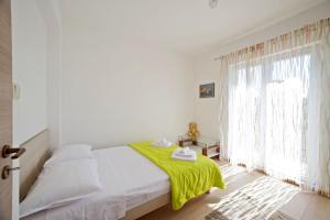 a bedroom with a bed with a green blanket on it at Apartments with a parking space Gornje selo, Solta - 15545 in Grohote