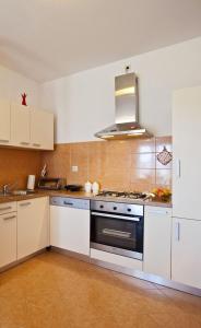 a kitchen with white cabinets and a stove top oven at Apartments with a parking space Gornje selo, Solta - 15545 in Grohote