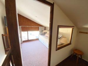 een slaapkamer met een spiegel en een bed in een kamer bij Appartement 2 pièces avec mezzanine près des pistes - 6 personnes - FR-1-815-81 in Morillon