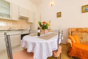 une cuisine avec une table et un vase de fleurs. dans l'établissement Apartments with a parking space Kastel Gomilica, Kastela - 15563, à Kaštela