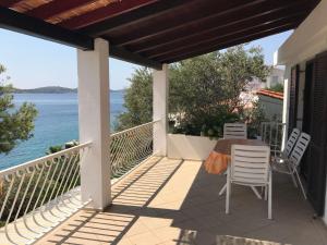 balcón con mesa, sillas y vistas al océano en Apartments by the sea Kaprije - 15567, en Kaprije