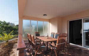 a dining room with a table and chairs on a balcony at Luxury villa with a swimming pool Supetarska Draga - Gonar, Rab - 15575 in Rab