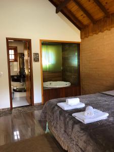 um quarto com uma cama e uma casa de banho com uma banheira em Terrace house em Monte Verde