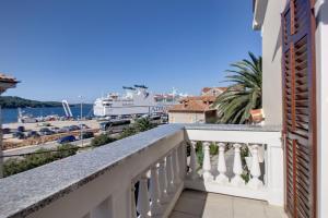 a balcony with a view of the water and a cruise ship at Apartments by the sea Mali Losinj (Losinj) - 15576 in Mali Lošinj