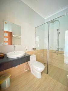 La salle de bains est pourvue de toilettes, d'un lavabo et d'une douche. dans l'établissement Chau Gia Hotel, à Vĩnh Hy
