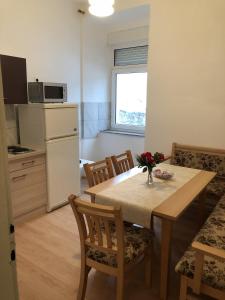 kuchnia ze stołem i krzesłami oraz kuchnia z lodówką w obiekcie Apartments by the sea Senj - 15578 w mieście Senj