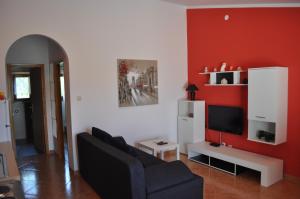 ein Wohnzimmer mit einem Sofa und einem TV in der Unterkunft Apartments with a parking space Pula - 15582 in Pula