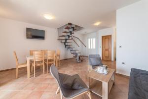 a living room with a table and chairs and a spiral staircase at Apartments by the sea Baric Draga, Karlobag - 15583 in Barić Draga