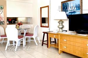 een woonkamer met een televisie en een tafel met stoelen bij New Aloha Ilikai 1free Parking in Honolulu