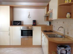 a small kitchen with white cabinets and a sink at Apartments with a parking space Risika, Krk - 15609 in Vrbnik