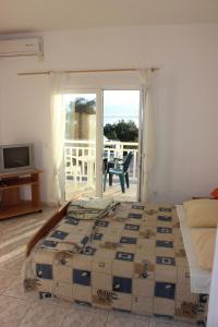 グラダツにあるApartments with a parking space Gradac, Makarska - 15628の大きなベッドとバルコニーのある寝室