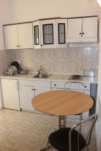 a kitchen with a wooden table and a table and chairs at Apartments with a parking space Gradac, Makarska - 15628 in Gradac