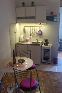 a small kitchen with a table and chairs and a sink at Apartments with a parking space Ugljan - 15613 in Ugljan